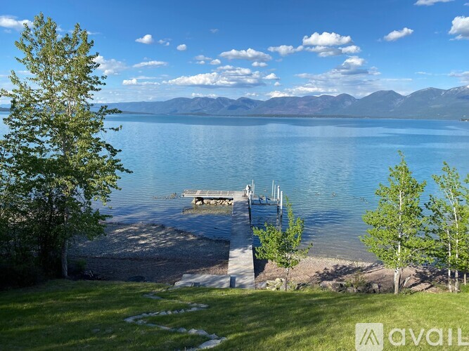 A serene lake surrounded by mountains and a clear sky.