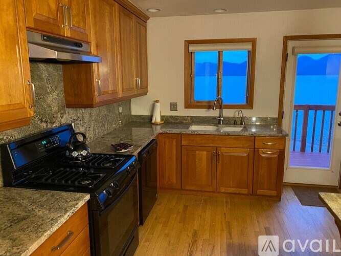 A kitchen with wooden cabinets and a black stove top.