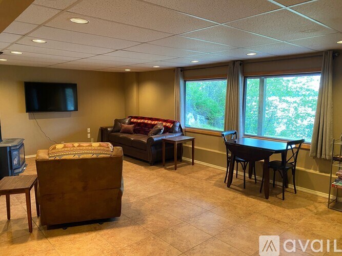 A living room with a couch, chair, and television.