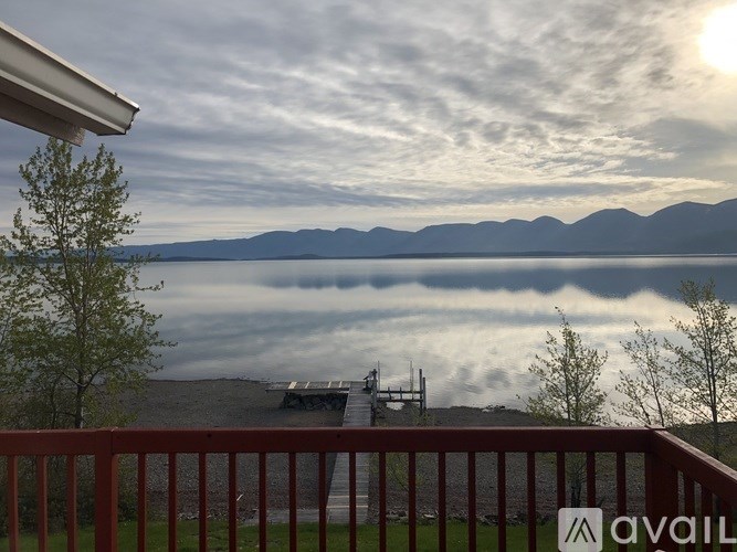 A view from a balcony overlooking a lake with mountains in the distance.