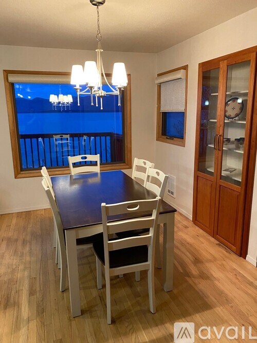 A dining room with a table and chairs.