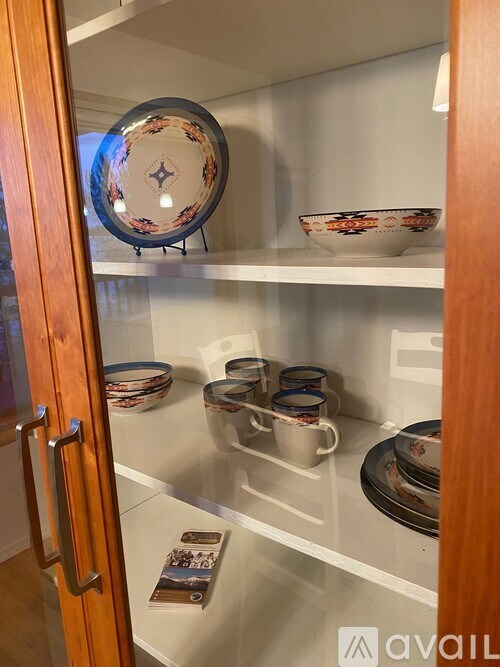 A kitchen cabinet with a plate and bowls on the shelf.