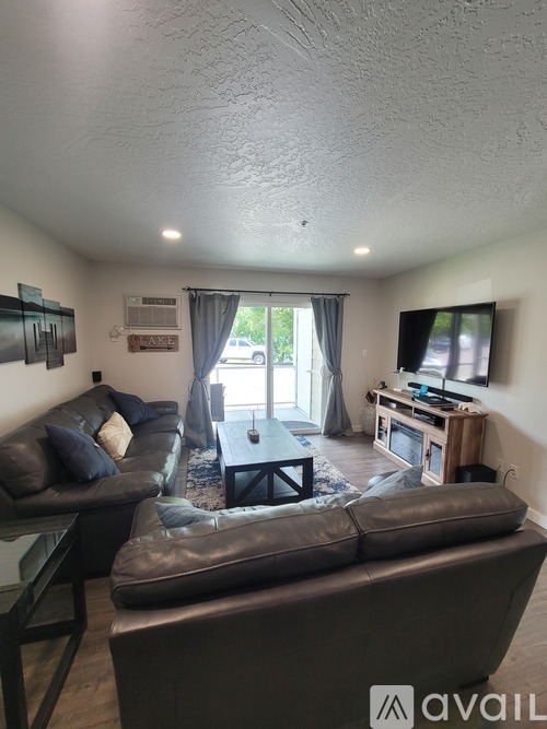 A living room with a couch, chair, and television.