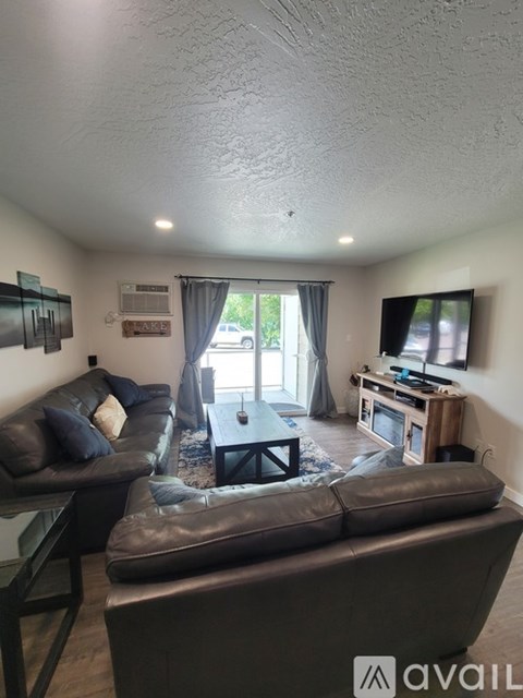 A living room with a couch, chair, and television.