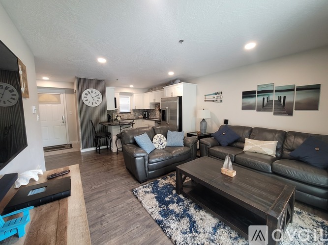 A living room with a black leather couch and a wooden coffee table.