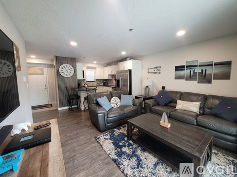 A living room with a black leather couch and a wooden coffee table.