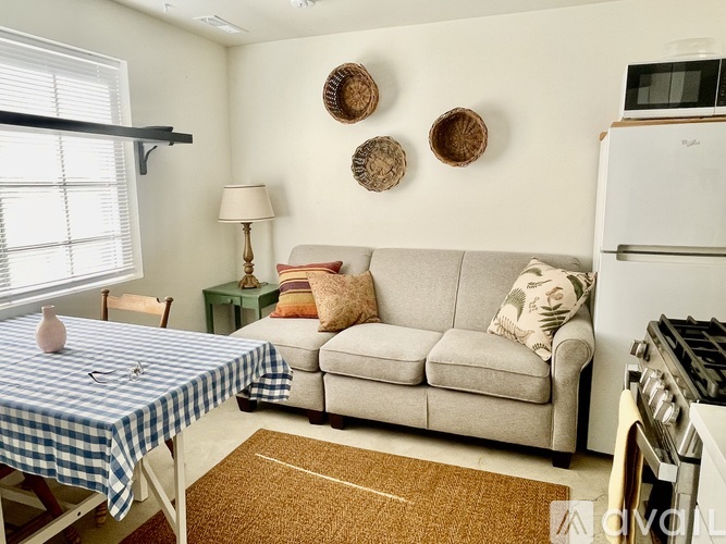 A living room with a couch, chair, and two lamps.