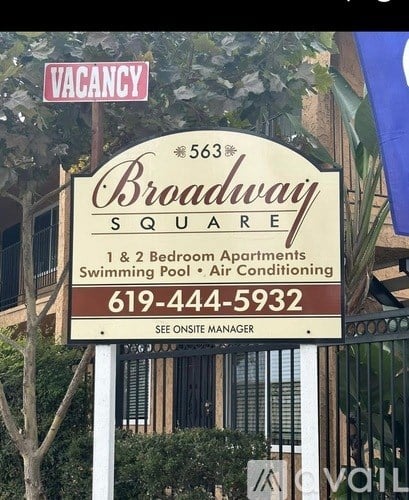 A sign for Broadway Square apartment complex with a phone number on it.