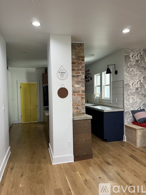 A room with a yellow door and a brick wall.