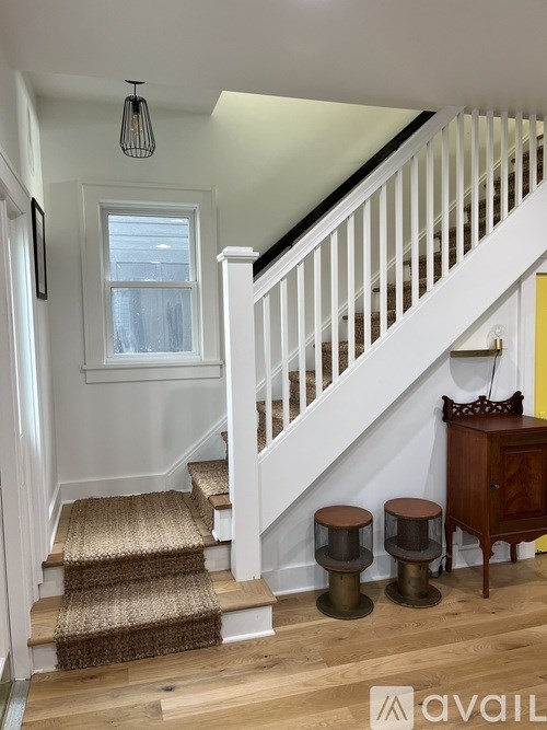 A staircase with a white banister and a brown carpeted runner.