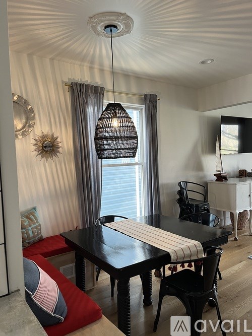 A dining room with a black table and chairs.