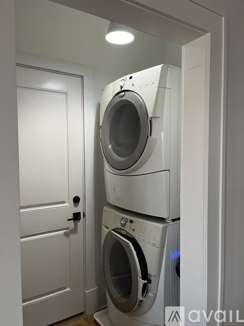 A white door is next to a stack of washing machines.