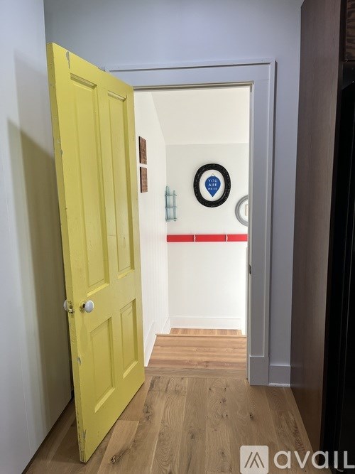 A yellow door is open to a hallway.