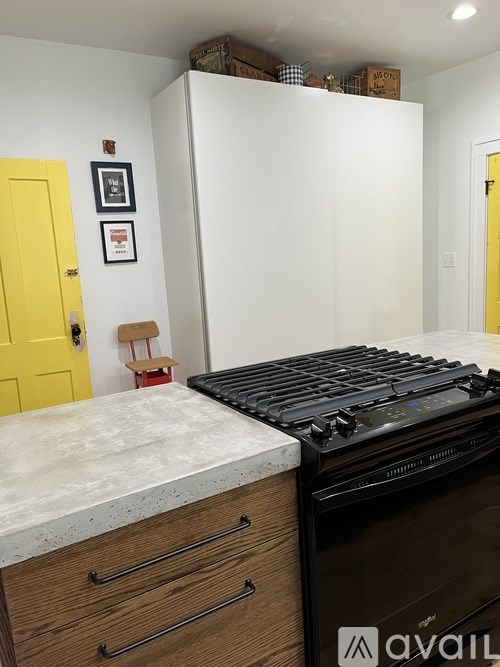 A kitchen with a black stove top oven and wooden drawers.