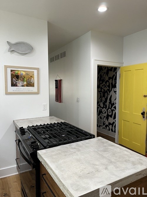 A kitchen with a white countertop and a yellow door.