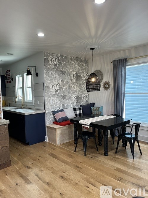 A dining room with a black table and chairs.