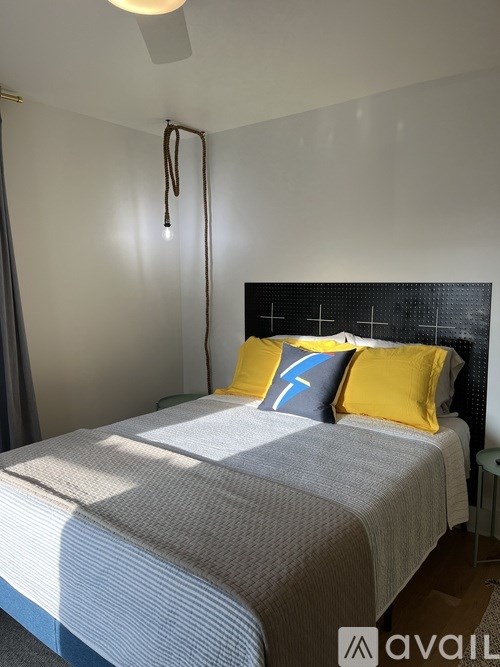 A bedroom with a bed, pillows, and a ceiling fan.