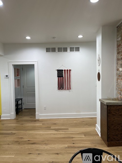 A room with a wooden floor and a flag hanging on the wall.