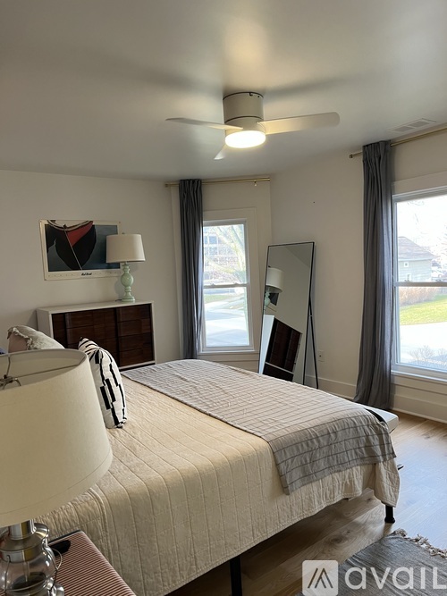 A bedroom with a large bed and a ceiling fan.