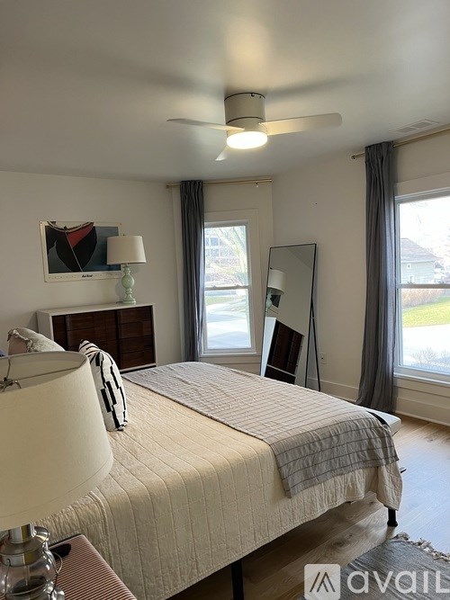 A bedroom with a large bed and a ceiling fan.