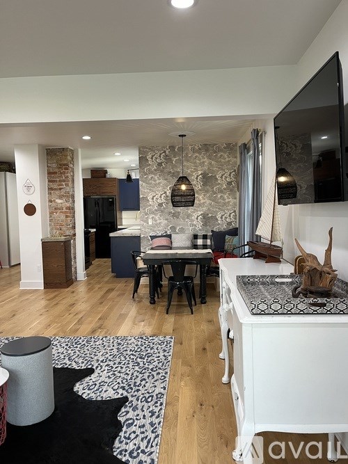 A kitchen with a white counter and a black and white rug on the floor.