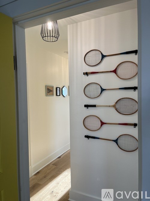 Tennis rackets are hanging on a wall in a room.
