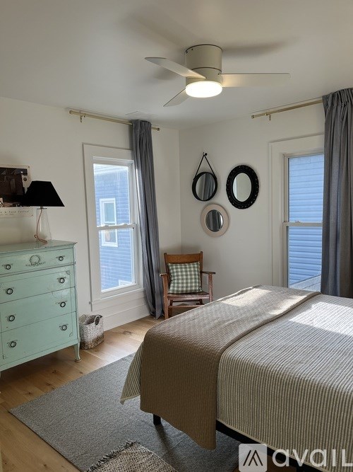 A bedroom with a bed, dresser, and window.