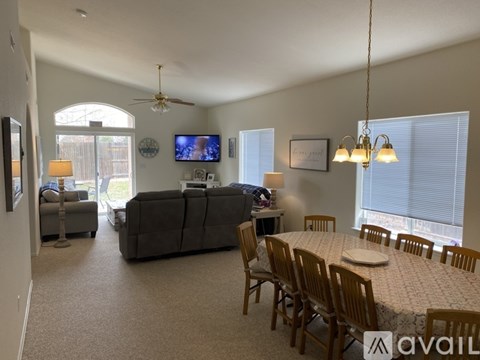 A living room with a grey couch and a television on the wall.
