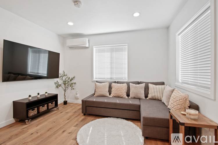 A living room with a brown couch, a television, and a wooden coffee table.