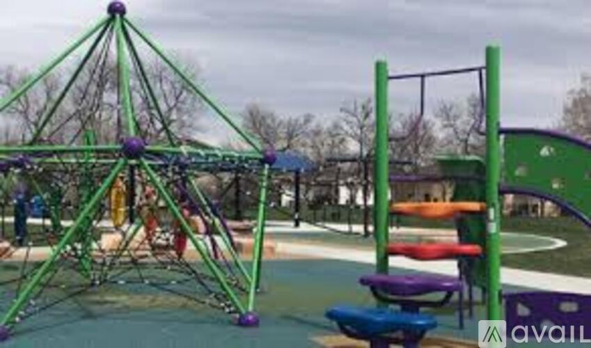 A playground with a green swing set and a climbing structure.