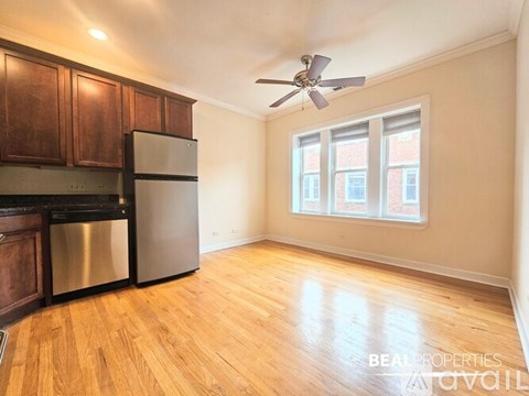 A kitchen with wooden cabinets and a stainless steel refrigerator.