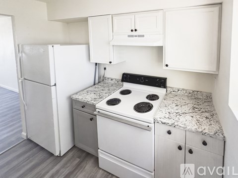 A kitchen with a white stove top oven and a white refrigerator.