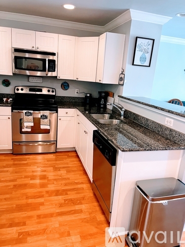 A kitchen with white cabinets and a black stove top oven.