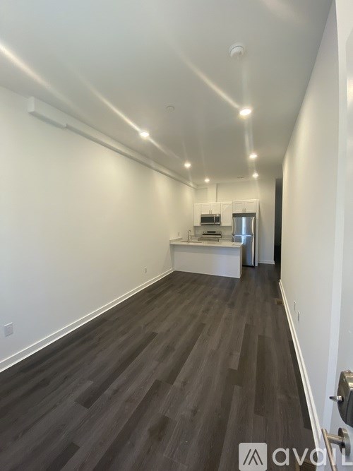 A long hallway with a kitchen area at the end.