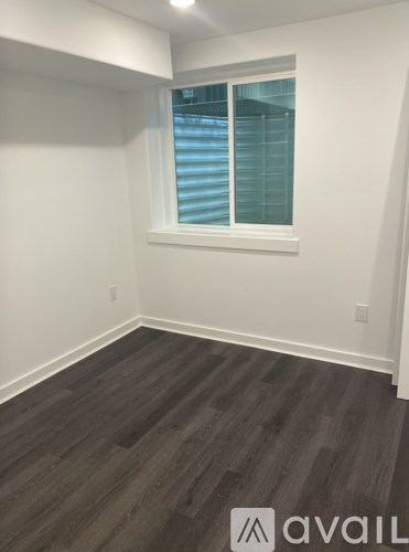 A room with a window and wooden flooring.
