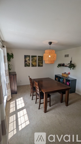 A dining room with a wooden table and chairs.