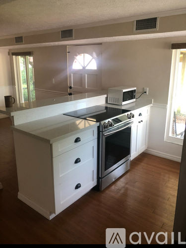 A kitchen with a white island and stove top oven.