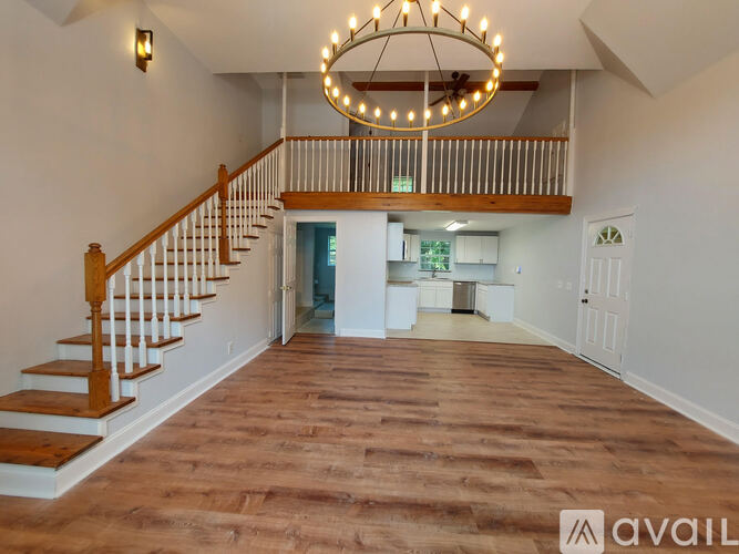 A large open room with a staircase and a chandelier.