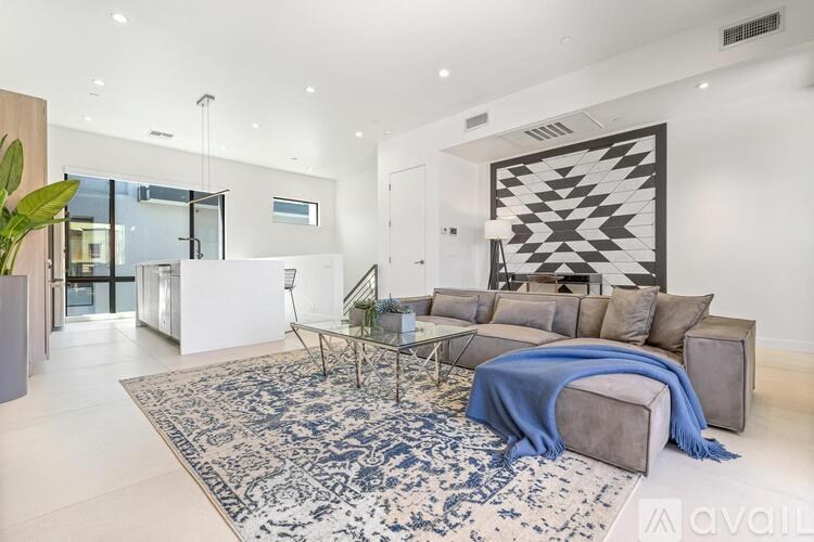 A living room with a grey couch and a blue blanket.