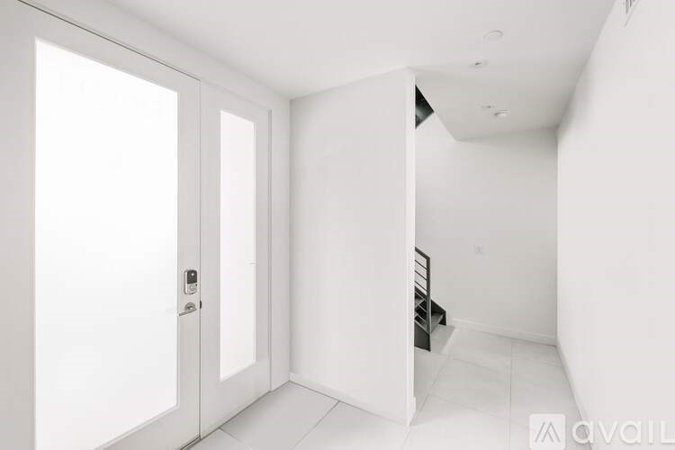 A white interior space with a door and a staircase.