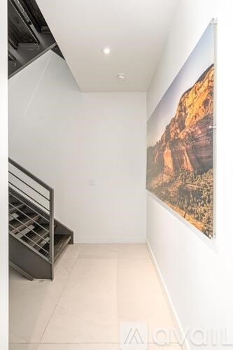 A large painting of a canyon is hanging on a white wall.