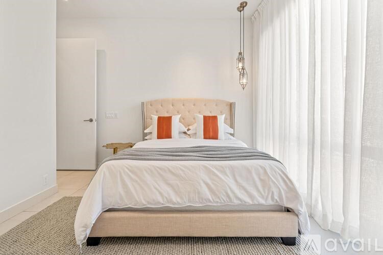 A bedroom with a large bed and a chandelier.