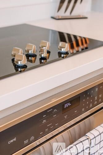 A close up of a stove top with four burners and a control panel below.