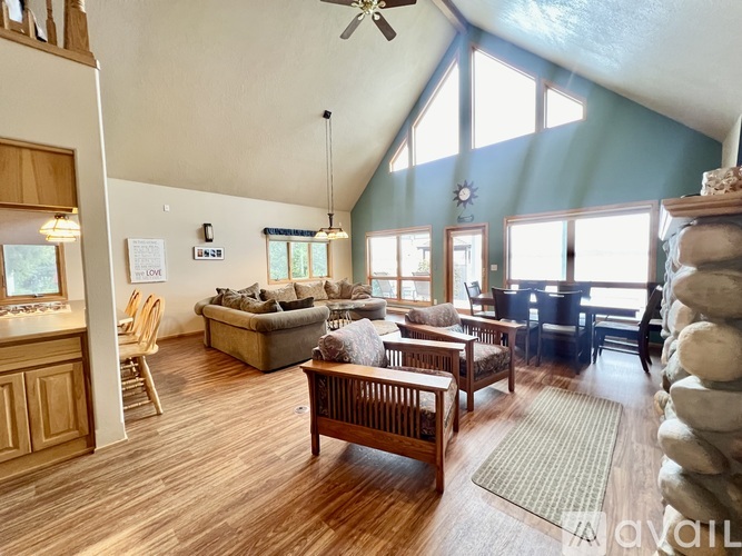 A spacious living room with a high ceiling and a variety of seating options.