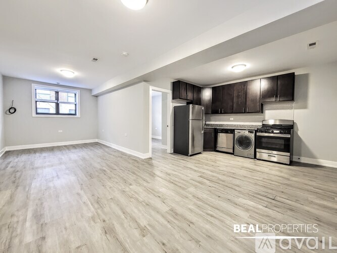 A spacious kitchen with wooden flooring and stainless steel appliances.
