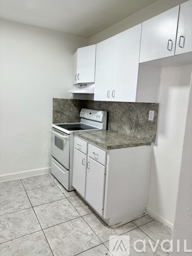A kitchen with white cabinets and a granite countertop.