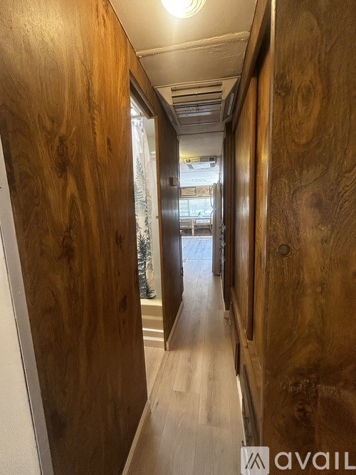 A collection of tea cups and glasses are displayed on a wooden shelf.