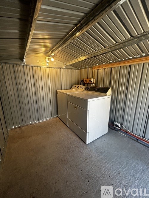 A white filing cabinet sits in a room with corrugated metal walls.