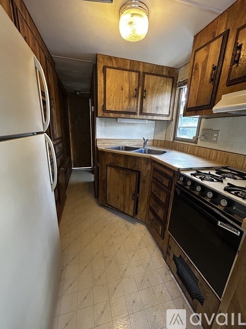 A kitchen with a white refrigerator and a black stove.