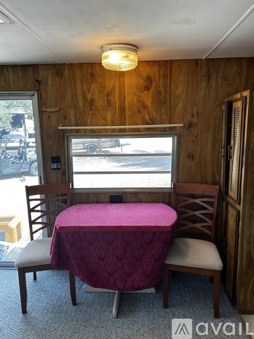 A wooden room with a table and chairs.